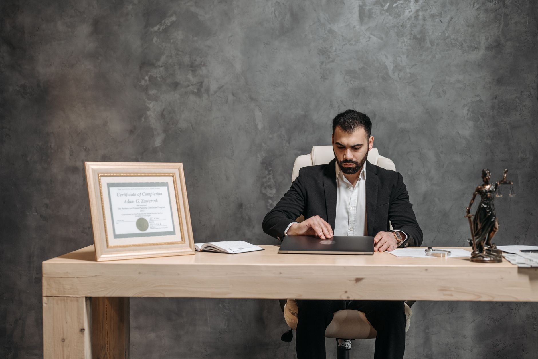A professional working carefully at a desk, reviewing materials with attention.
